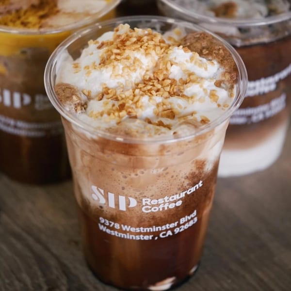 Close-up of a Vietnamese iced coffee with whipped cream and crushed nuts from Sip Restaurant & Coffee.