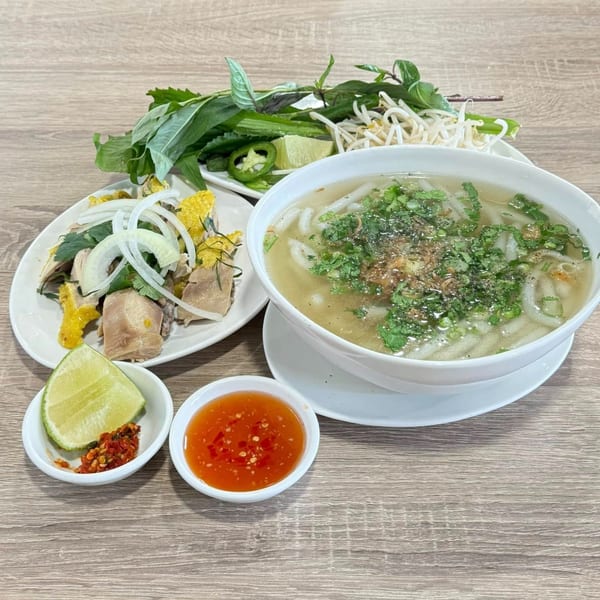 Vietnamese chicken noodle soup, a side of chicken salad, fresh herbs, and dipping sauces.